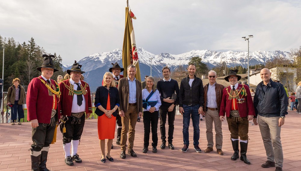 Start des Sommerbetriebes Sportanlage Zimmerwiese Igls: Innsbrucks Bürgermeister Georg Willi (5. v. l.), Sportstadträtin Elisabeth Mayr (3.v.l.), Sportamtsleiter Romuald Niescher (r.), Maria Zimak (Unterausschuss Igls, 6. v. l.), Obmann Karl Zimmermann (3. v. r., Agrargemeinschaft Igls), Hauptmann Christoph Wegscheider (Schützenkompanie Igls-Vill, l.) und Obmann Herwig Zöttl (2. v. r.) Kapellmeister Klaus Graf von der Musikkapelle Igls-Vill (2. v. l.) sowie Vertreter der Innsbrucker Immobiliengesellschaft und des Architekturbüros stimmten sich beim Eröffnungsfest auf die sportliche Sommersaison in Igls ein.