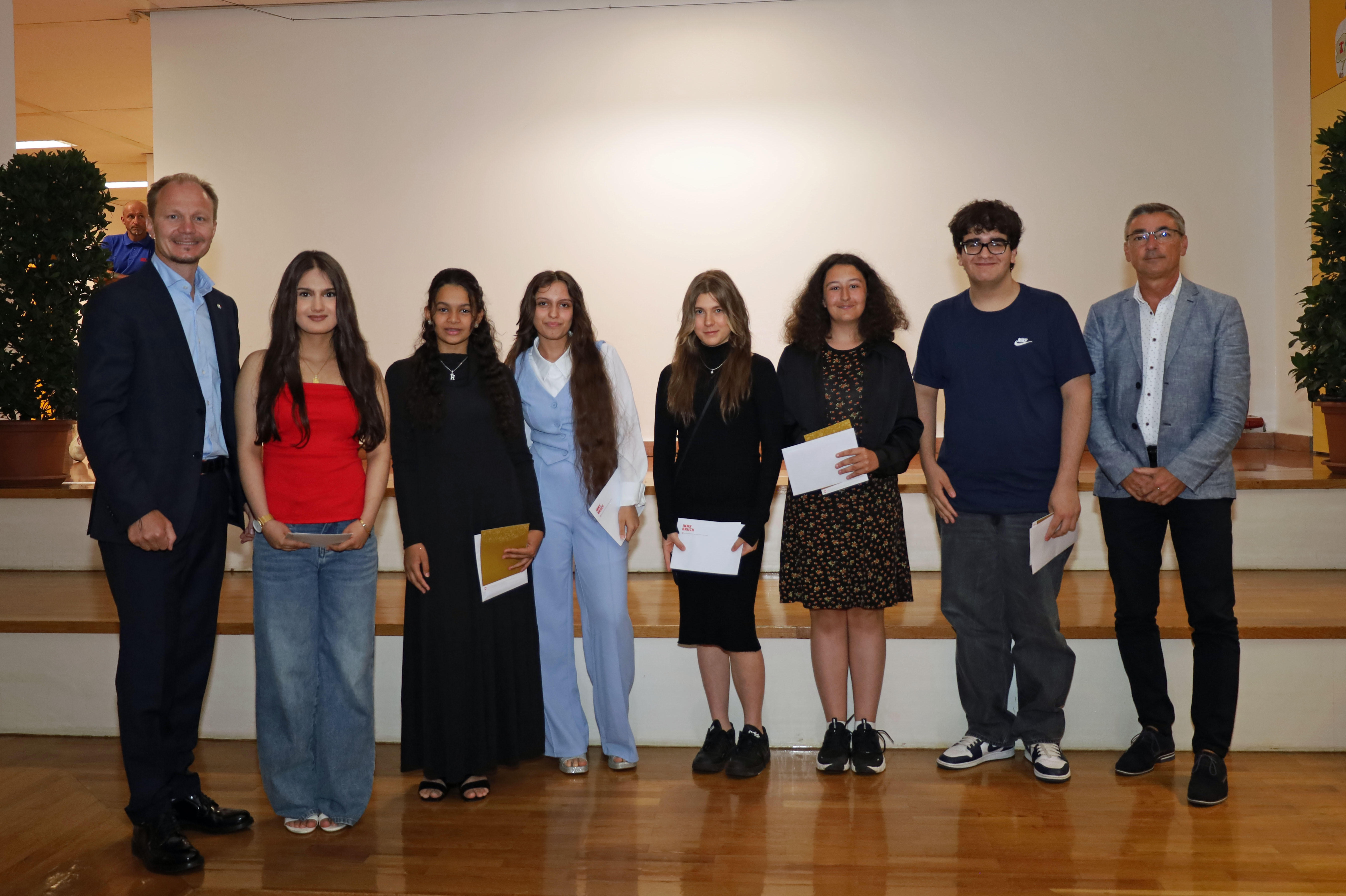 Bürgermeister Johannes Anzengruber (l.) und Schulqualitätsmanager Dietmar Meinschad (r.) mit den ausgezeichneten SchülerInnen der Mittelschule Olympisches Dorf.