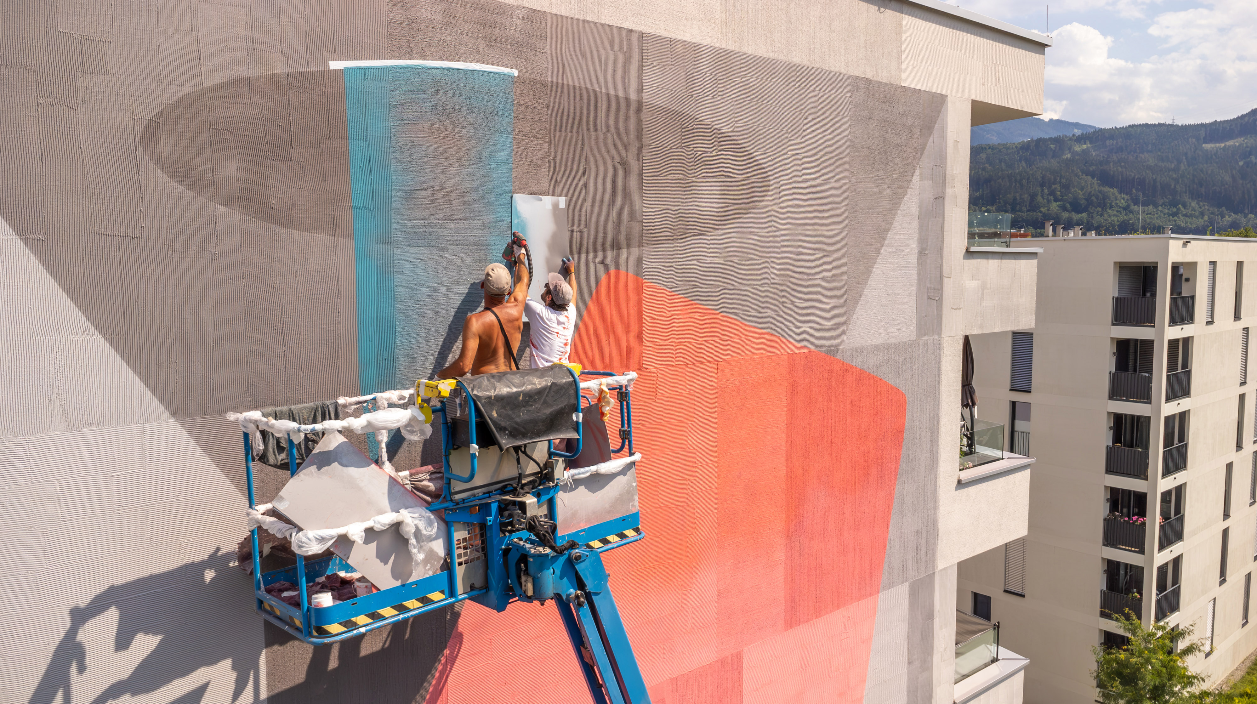 Künstler NiKoDeM beim Erstellen seines Murals auf der Nordseite des Wohngebäudes.