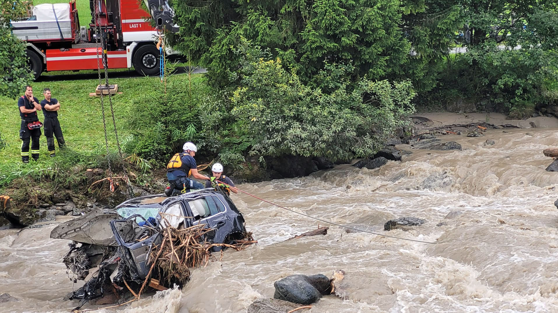 Einsatzkräfte der Berufsfeuerwehr bergen ein Wrack aus den Strömen der Rosanna.