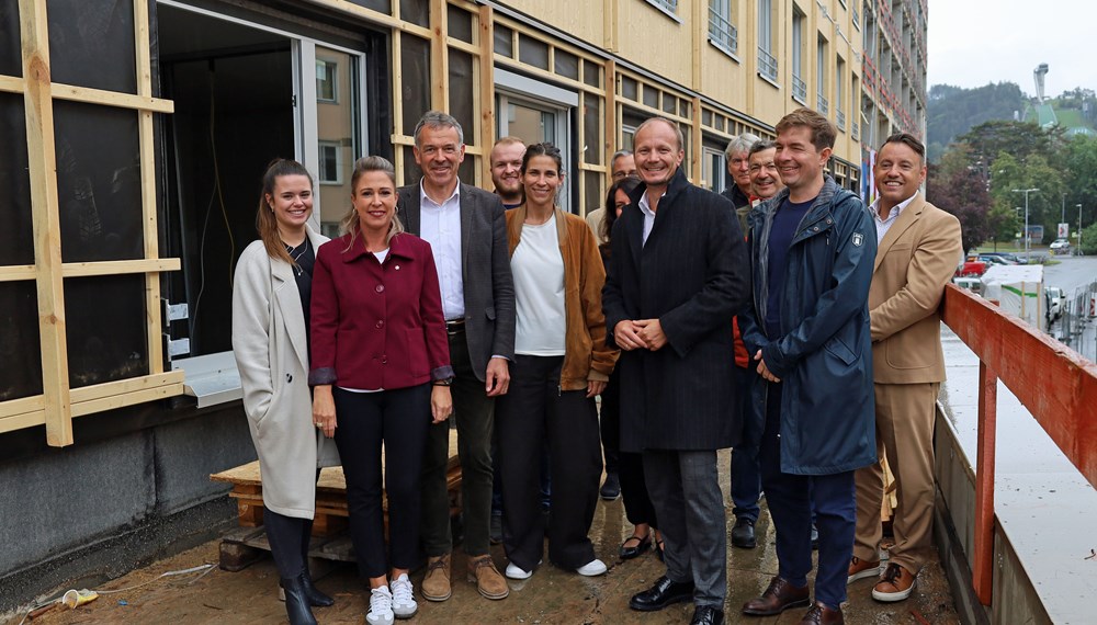 v.l.n.r.: Bauausschuss-Vorsitzende Julia Payr, Stadträtin Mariella Lutz, Vizebürgermeister Georg Willi, Stadträtin Janine Bex, Bürgermeister Johannes Anzengruber, Gemeinderat Mario Dallaserra, IIG-Geschäftsführer Franz Danler sowie (im Hintergrund) das ArchitektInnenduo Betina Hanel und Gerhard Manzl, Geschäftsführer Günther Jedliczka (OeAD student housing), Zoltan Gal von der Firma Kitzberger (Inneneinrichtung) und ein Vertreter der Baufirma Bodner.