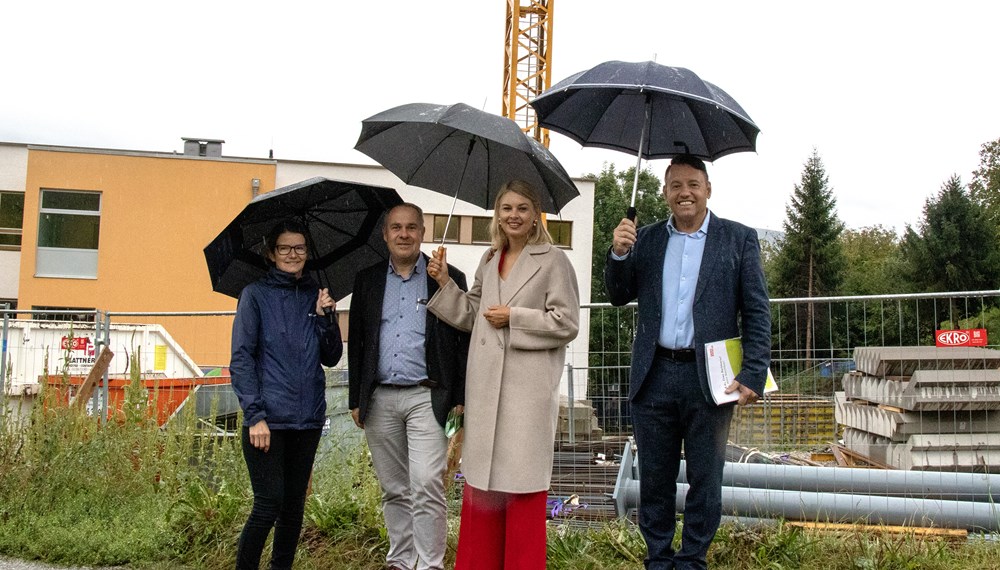 Direktorin Petra Eichler, Projektleiter Walter Aistleitner, Vizebürgermeisterin Elisabeth Mayr und IIG-Geschäftsführer Franz Danler trotzten dem Regenwetter und machten sich ein Bild vom Baufortschritt bei der Volksschule Arzl.