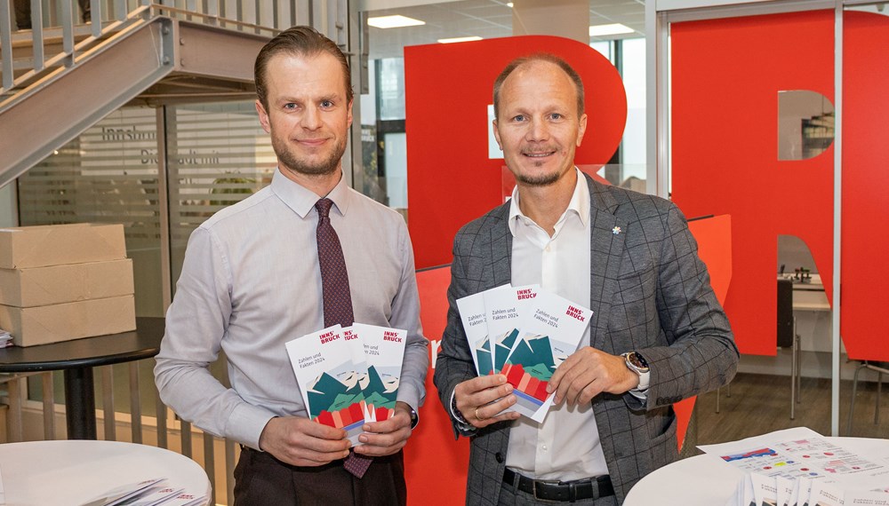 Bürgermeister Johannes Anzengruber (r.) und Amtsvorstand Mathias Behmann (l.) präsentieren die neue Statistikbroschüre der Stadt Innsbruck vor dem Bürgerservice, wo sie ab sofort erhältlich ist.