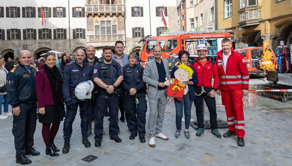 Bürgermeister Johannes Anzengruber, (4.v.r.), Stadträtin Mariella Lutz (2.v.l.), Referentin Uschi Klee (3.v.r.), Amtsvorstand Christian Schneider (6.v.r.) und André Lomsky (Innsbruck Tourismus, 4.v.l.) freuen sich gemeinsam mit den VertreterInnen der Innsbrucker Berufsfeuerwehr, der Polizei, der MÜG, des Roten Kreuzes und der Bergrettung über ein gelungenes „Peterle hilft“-Fest.