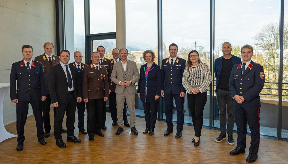 Bürgermeister Johannes Anzengruber (6.v.r.), Magistratsdirektorin Gabriele Herlitschka (5.v.r.), Branddirektor Helmut Hager (4.v.r.), IIG-Geschäftsführer Franz Danler (3.v.l.), Architekt Sebastian Neuschmid (2.v.r.) und Rotes-Kreuz-Geschäftsführerin Alexandra Tanda (3.v.r.) und die Funktionäre der Feuerwehr bei der Übergabefeier im Neubau.