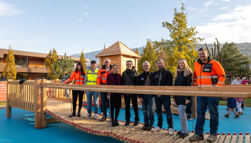 Stadträtin Mariella Lutz (4. v. l.), Referatseiter Markus Pinter (5. v. l., Grünanlagen – Planung und Bau) mit seinem Team sowie die Mitarbeitenden der Firma Strabag freuen sich über die gelungene Erweiterung des Spielplatzes Tivoli.
