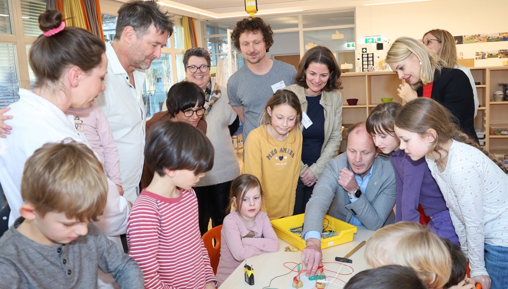 Spielerisches Forschen ist im neuen „MI(N)Tmachraum“ im Kindergarten und Schülerhort Angergasse möglich: Bürgermeister Johannes Anzengruber (sitzend), Bildungsreferentin Vizebürgermeisterin Elisabeth Mayr (stehend rechts) und GRin Karoline Obitzhofer (Bildungsausschuss, stehend links) machten sich ein Bild von der neuen „Tüftlwerkstatt“.