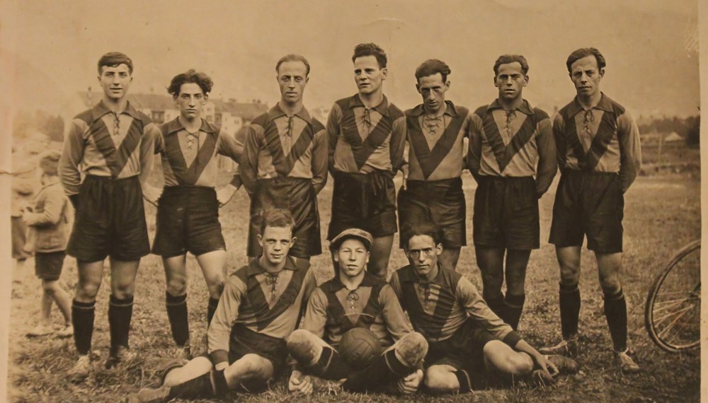 Mannschaftsfoto des völlig in Vergessenheit geratenen Sportklubs Hertha Innsbruck. Er wurde 1929 als Arbeiterverein gegründet und 1934 vom austrofaschistischen Regime aufgelöst. Sieben der Spieler auf dem Foto entstammen der jüdischen Innsbrucker Familie Löwy mit Wurzeln in Bratislava. Zahlreiche Familienmitglieder wurden in KZs ermordet.