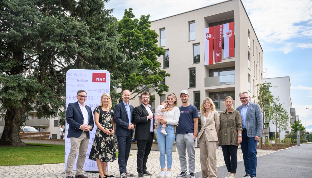 NHT-/Stadtbau-Geschäftsführer Markus Pollo begrüßt mit Bürgermeisterstellvertreterin Elisabeth Mayr, Bürgermeister Johannes Anzengruber, Gemeinderat Benjamin Plach, Landtagsabgeordneter Daniela Meichtry, Stadträtin Mariella Lutz und NHT-Geschäftsführer Johannes Tratter Familie Ikic im neuen Zuhause.