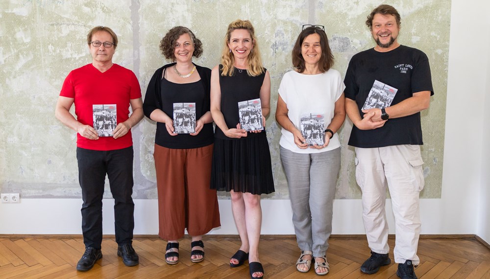 (v.l.n.r.) Die HistorikerInnen Horst Schreiber und Barbara Hausmair, Kulturamtsleiterin Isabelle Brandauer sowie Heike Bablick und Karl-Heinz Machat von der Werkgemeinschaft mit der neuen Broschüre „Gedenkort Lager Reichenau: Geschichte und Zukunft“, die einen Überblick aktueller Forschungsergebnisse zum Lagerkomplex Reichenau bietet.