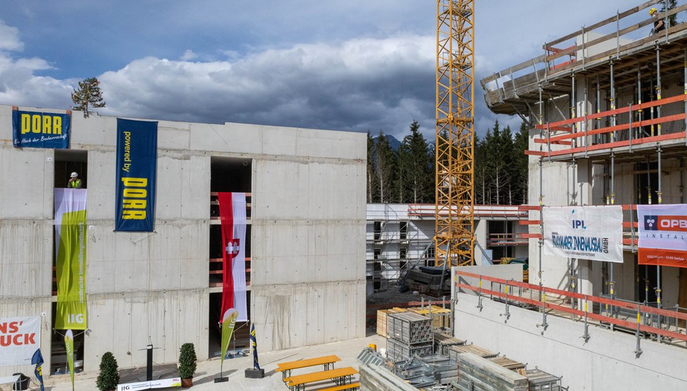 Mit „Am Bichl III“ realisiert die IIG eines der ersten drei Plus-Energie-Quartiere Österreichs und eines der hundert ersten dieser Art in Europa: Die neue Wohnanlage erzeugt bilanziell über das Jahr mehr Energie, als sie verbraucht. (Im Bild bei der Firstfeier im September 2024)