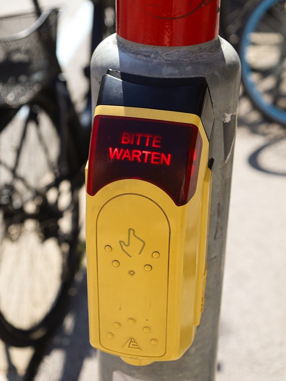 Akustische Signalgeber bei Ampeln und taktile Leitlinien helfen sehbeeinträchtigten Menschen, sich selbstständig und sicher durch die Stadt zu bewegen.