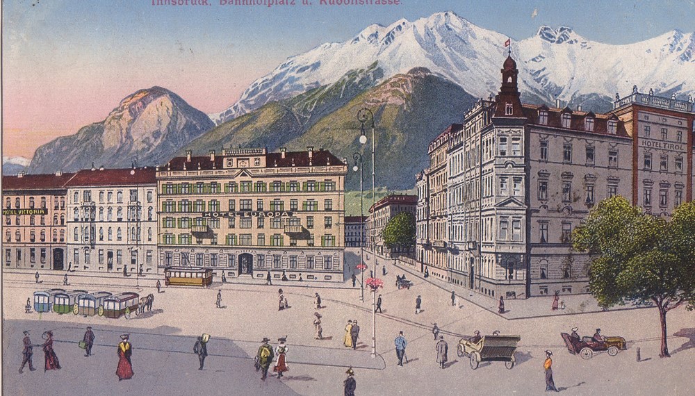 Blick vom Südtiroler Platz (damals Bahnhofplatz bzw. Bahnstraße) in die Brixner Straße (damals Rudolfstraße) in Richtung Westen. Links das Hotel Europa (damals Bahnstraße 14 = heute Südtiroler Platz 2), am rechten Bildrand das Hotel Tyrol. (Postkarte koloriert, 1917)