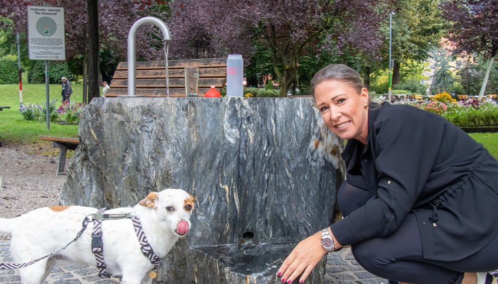 Durst gelöscht – nicht nur bei Zweibeinern: Stadträtin Mariella Lutz und ein vierbeiniger Parkgast beim „Geschmackstest“ des neuen Brunnens.