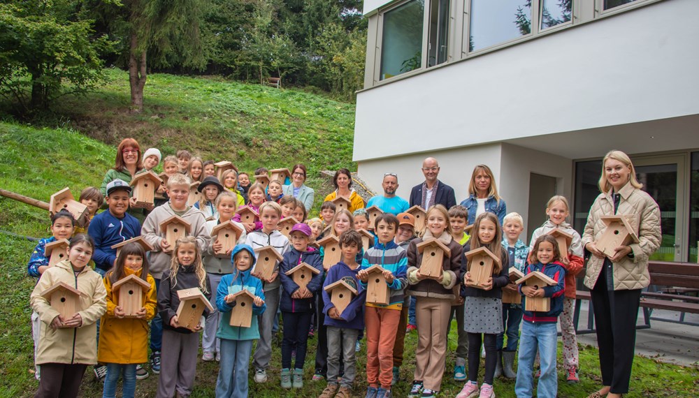 Die Kinder der 3a und 3b der VS Arzl freuten sich über ihre eigenen Nistkästen. Auch Vizebürgermeisterin Elisabeth Mayr (vorne re.), Direktorin Petra Eichler (hinten, 5. v. r.), die Klassenlehrerinnen Andrea Weißkopf-Köck (l.) und Manuela Gutmann-Marquardt (hinten, 4. v. r.), Schulwart Oliver Tschank (hinten, 3. v. r.), Schulamtsleiter Werner Leithmayer (hinten, 2. v. r.) sowie die Projektverantwortliche Isabella Prossliner (hinten re.) teilten die Freude mit den Kindern über das nachhaltige Vogelschutzprojekt.