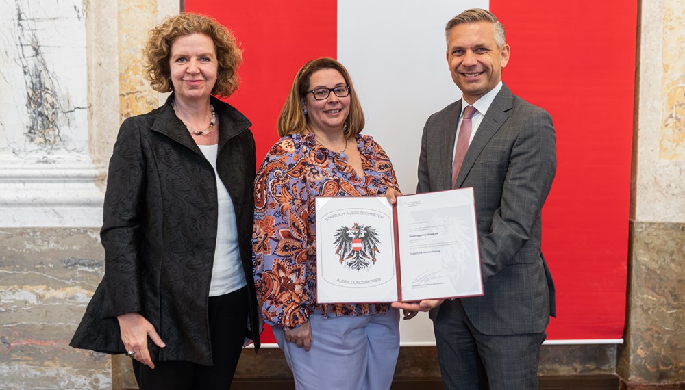 (v. l.) Magistratsdirektorin Gabriele Herlitschka und Lehrlingsbeauftragte Sabine Floßmann nehmen im Namen der Stadt Innsbruck das Gütesiegel „Staatlich ausgezeichneter Ausbildungsbetrieb“ von Bundesminister Wolfgang Hattmannsdorfer entgegen.