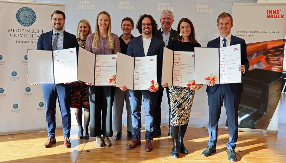 Vizebürgermeisterin Elisabeth Mayr (hinten links), Rektor der Medizinischen Universität Gert Mayer (hinten rechts) und Patrizia Stoitzner, Vizerektorin für Forschung und Internationales an der Med-Uni Innsbruck, freuen sich mit den diesjährigen PreisträgerInnen Ivan Lechner, Marina Schapfl, Simone Pelizzari, Theresa Hautz-Neunteufel und Stefan Salchner.