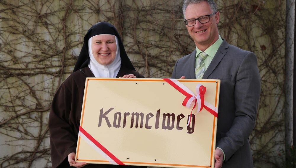 Stellvertretend für Bürgermeisterin Christine Oppitz-Plörer übergab Christian Tschaikner die Straßentafel "Karmelweg" an die ehrwürdige Mutter Carmen, Leiterin des Karmelitinnenklosters.
Die Karmelitinnen feiern heuer das 500-Jahr-Jubiläum anlässlich des Geburtsjahres 1515 der Ordensgründerin Teresa von Avila. Aktuell leben neun Schwestern im Kloster in Mühlau.