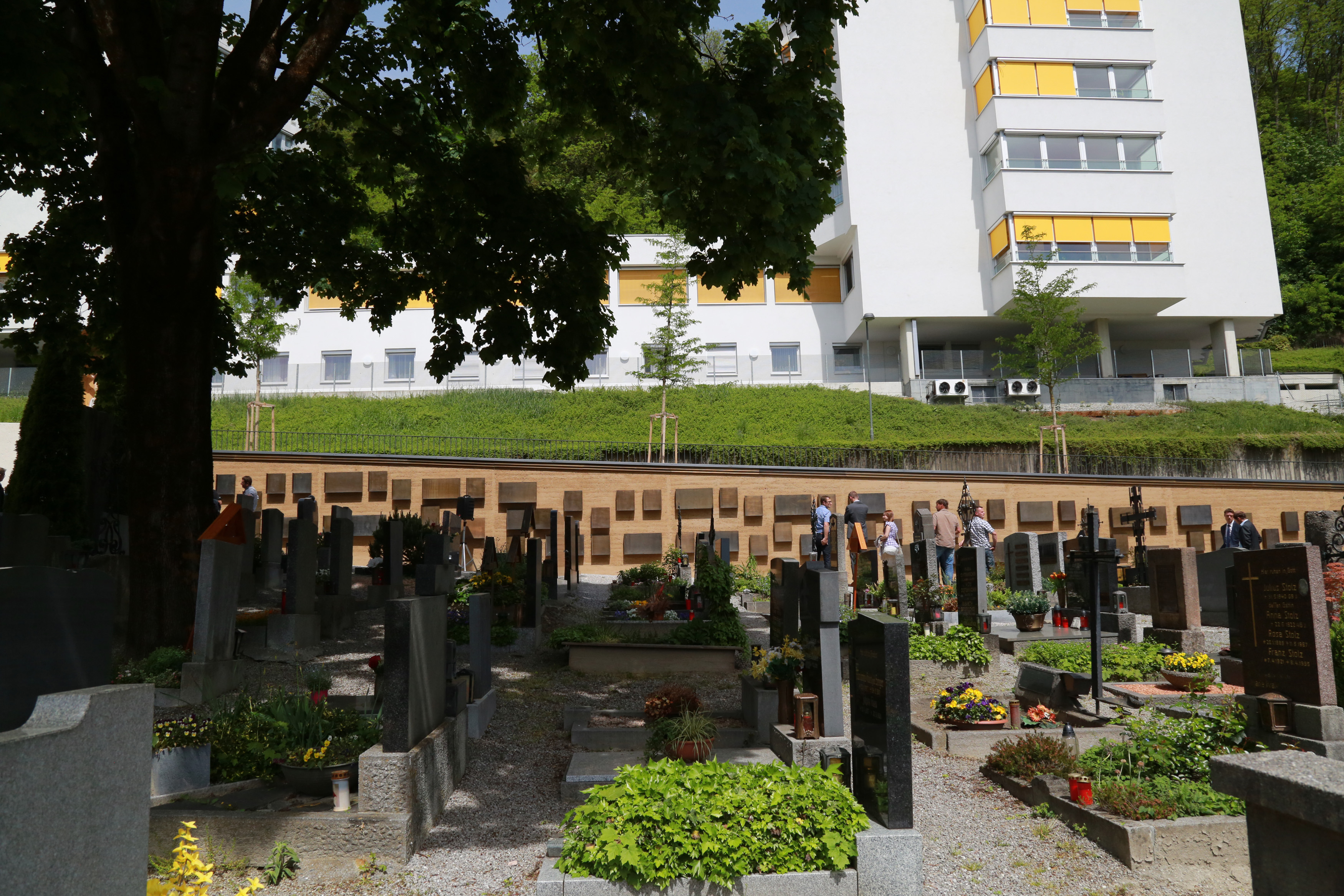 Durch die besondere Struktur und Beschaffenheit der Stampflehms, integriert sich die nördliche Begrenzungswand sehr gut in das Bild des Höttinger Friedhofs.