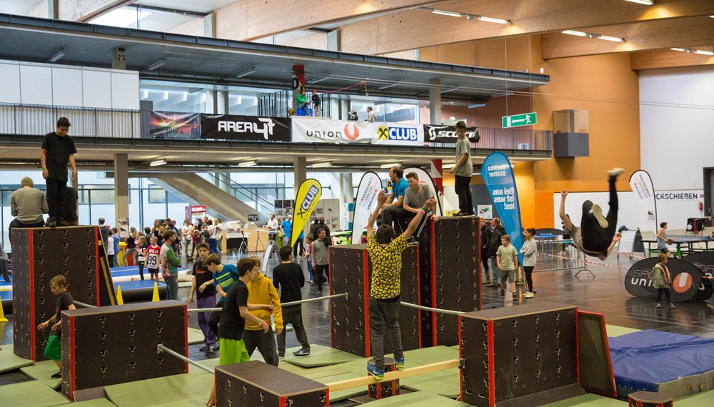 Freerunning, Airtrack, Longboarden, BMX, Slacklining, Floorball, Selbstverteigdigung für Mädchen, Hip Hop, Speedtennis und Skateboarden – dies sind nur einige der vielen Sportarten, die die Burschen und Mädls in die Messehalle D lockte.
Am Freitag war die U Tour reserviert für 400 SchulerInnen aus dem Raum Innsbruck und Umgebung und Schauplatz eines besonderen Wettkampfes - der School Challenge – bei dem sich Zweierteams in vier Sportarten bei lautstarker Anfeuerung ihrer KlassenkammeradInnen messen konnten.
Am Samstag öffnete die U Tour dann für Jung und Alt – jede/r war willkommen. Bereits vor Eventbeginn fanden sich die ersten Jugendlichen vor der Halle ein und konnten es kaum erwarten, mit dem Flying Fox durch die Halle zu fliegen, über die Skate- und BMX-Rampen zu springen, sich im Go-Kart-Rennen zu „batteln“ oder auch den Adrenalin-Kick, bei einem Sprung in den AIR2BAG aus acht Meter Höhe, zu erleben. Ab Mittag wurde die Halle regelrecht gestürmt von trendsportbegeisterten Jugendlichen, die keine Zeit zum Verschnaufen hatten: zu vielfältig und zu spannend war das Angebot, das alle in Bewegung hielt.