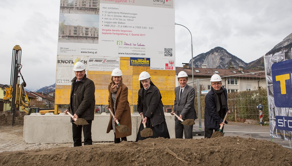 Im November begann der Bau von „Haus im Leben“ in der Höttinger Au in Innsbruck: Das Projekt im Geviert Fürstenweg, Amberggasse, Pirmingasse und Daneygasse, dessen Fertigstellung bis Mitte 2017 geplant ist, realisiert generationsübergreifendes, betreutes Wohnen und Leben auf einer Gesamtfläche von 5.000 Quadratmetern. Zur dörflichen Struktur zählen 53 Wohneinheiten sowie u. a. eine Hebammenpraxis, eine Kinderkrippe und ein Café.
Beim Spatenstich (v.l.): Wilhelm Haberzettl (Vorstandsvorsitzender BWSG), Bürgermeisterin Christine Oppitz-Plörer, Sr. Hildegard Wolf (Oberin Konvent der Ursulinen), Anton Stabentheiner (Haus im Leben), Architekt Manfred Gsottbauer