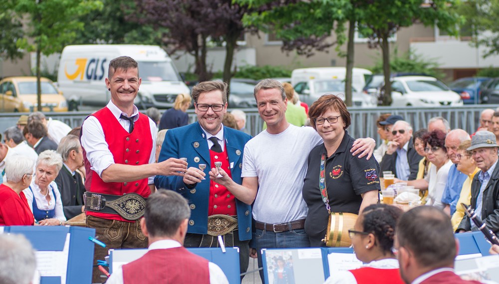 Vizebürgermeister Christoph Kaufmann eröffnete das Platzkonzert der Speckbacher Musikkapelle am DDr. Alois Lugger Platz. Gemeinsam mit der Pfarre St. Pius X und der Freiwilligen Feuerwehr Neu Arzl organisierte die Speckbacher Musikkapelle einen Frühschoppen im Olympischen Dorf .