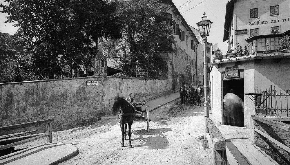 Fuhrwerke in der Schneeburggasse, um 1920. Rechts im Bild das Gasthaus mit der Hausnummer 12, in dem sich das Höttinger Gemeindeamt befand.