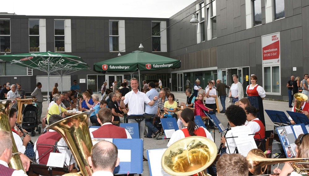 Die Speckbacher Musikkapelle Neu Arzl/Olympisches Dorf veranstaltete am DDr.-Lugger-Platz ihr traditionelles Platzkonzert. Vizebürgermeister Christoph Kaufmann bedankt sich bei den MusikantInnen für ihren Einsatz.