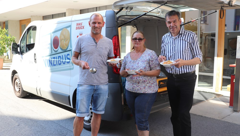 Gemeinsam mit seiner Kollegin Sylvia Walter (M) fährt Reinhold Happ (l.) jeden zweiten Montag sowie am Heiligen Abend mit dem Vinzibus durch Innsbruck und versorgt bedürftige Menschen mit einer warmen Mahlzeit. Von dieser ehrenamtlichen Tätigkeit machte sich Bürgermeister Georg Willi kürzlich selbst ein Bild. Zwischen 50 und 60 Essen werden zur Zeit täglich an drei Standorten (Pauluskirche, Wolfgangstube und hinter der Markthalle) an jene Personen ausgegeben, die es benötigen. Bürgermeister Willi dankte den Freiwilligen für ihr Engagement - das auch bei über 30 Grad Celsius im Schatten unermüdlich ist.