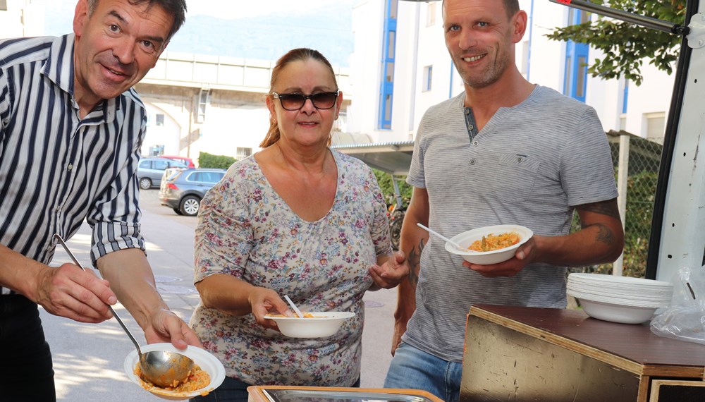 Gemeinsam mit seiner Kollegin Sylvia Walter (M) fährt Reinhold Happ (l.) jeden zweiten Montag sowie am Heiligen Abend mit dem Vinzibus durch Innsbruck und versorgt bedürftige Menschen mit einer warmen Mahlzeit. Von dieser ehrenamtlichen Tätigkeit machte sich Bürgermeister Georg Willi kürzlich selbst ein Bild. Zwischen 50 und 60 Essen werden zur Zeit täglich an drei Standorten (Pauluskirche, Wolfgangstube und hinter der Markthalle) an jene Personen ausgegeben, die es benötigen. Bürgermeister Willi dankte den Freiwilligen für ihr Engagement - das auch bei über 30 Grad Celsius im Schatten unermüdlich ist.